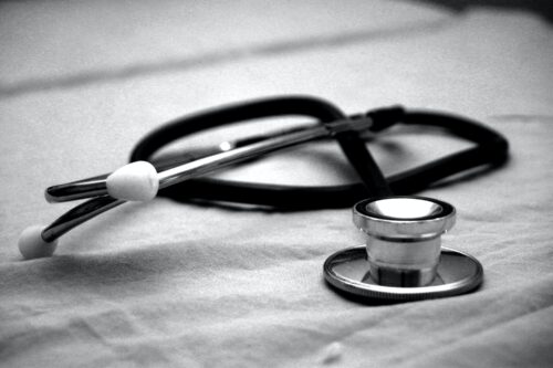 A stethoscope rests on a fabric surface in a black‑and‑white image.