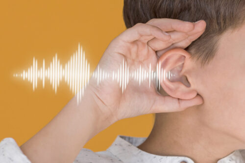 A person holds a hand to their ear with a white soundwave graphic shown beside it.