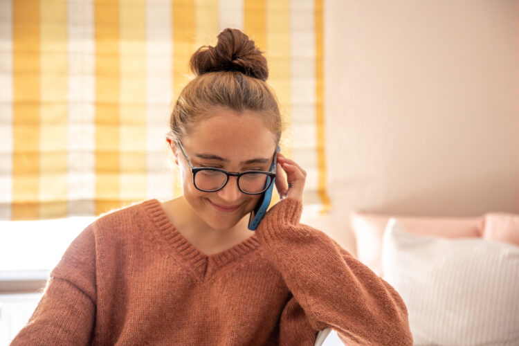 Young person talking on a mobile phone at home.