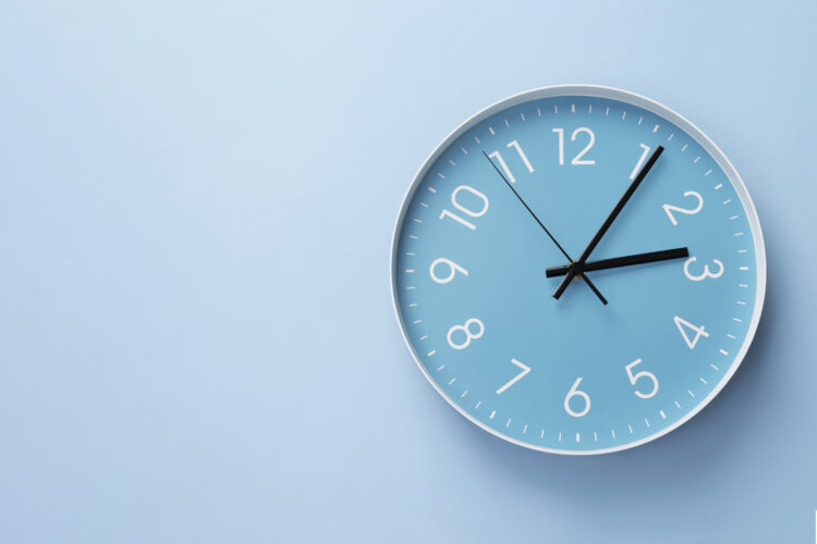 Blue wall clock on a light blue background.