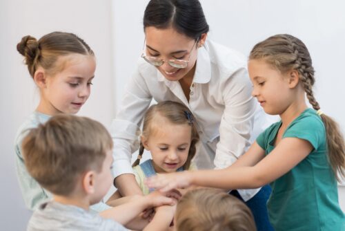 Adult leading a group activity with young children.